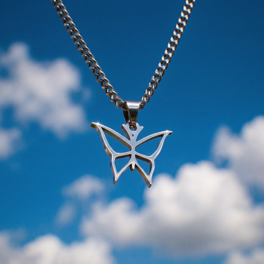 Butterfly Necklace II in silver stainless steel, hanging against a blue sky
